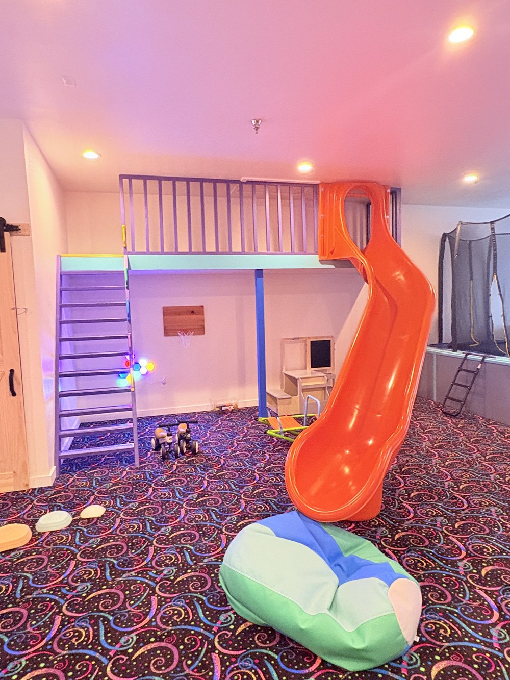 Orange slide, climbing stairs and soft landing cushions at The Grove