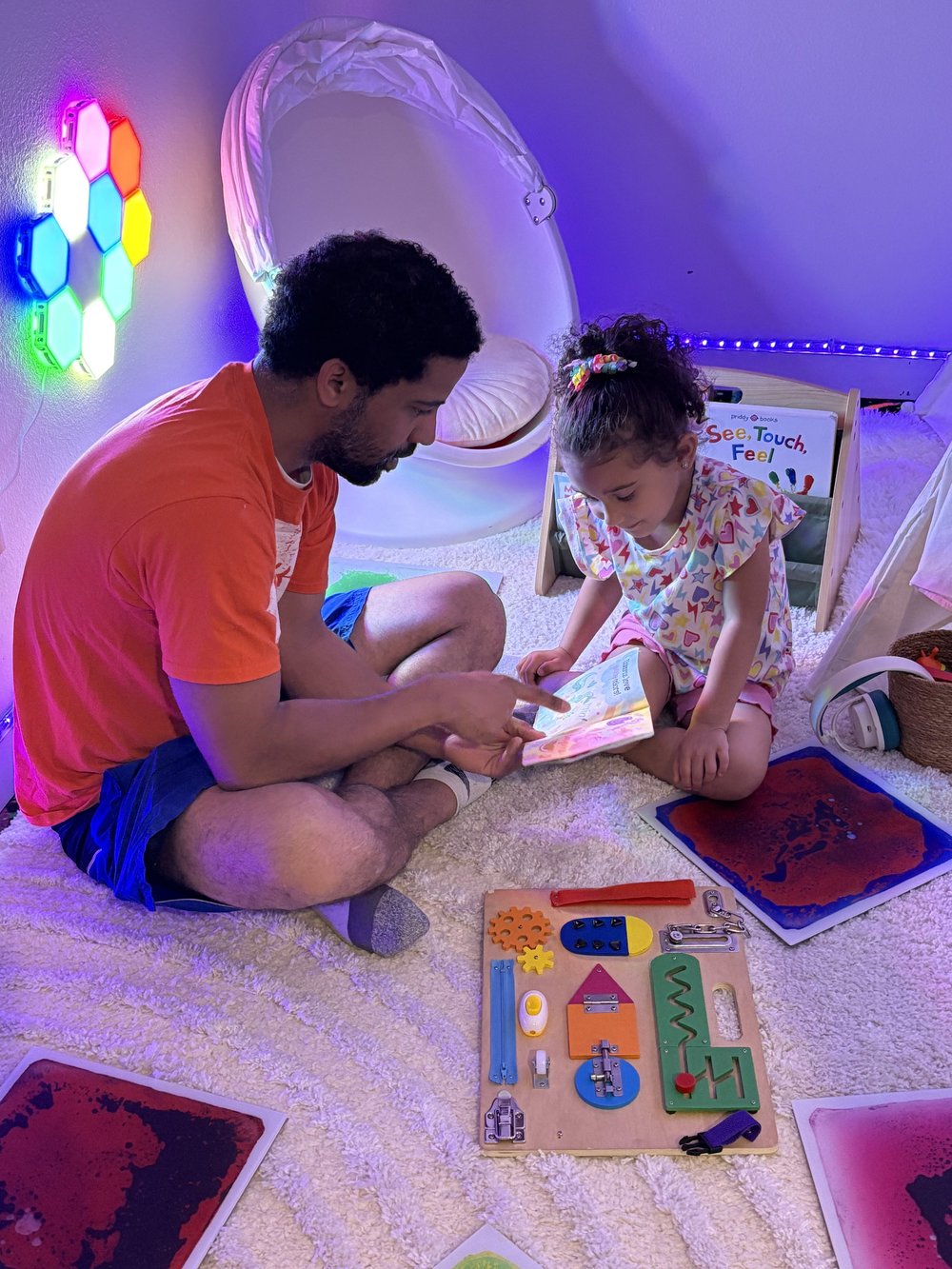 An adult and child sharing a book in The Grove’s sensory room